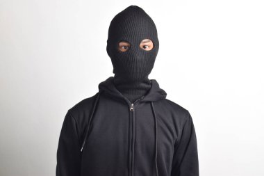 Beyaz arka planda siyah ceket ve maske giyen bir hırsız. Hırsızlık ve suç kavramı