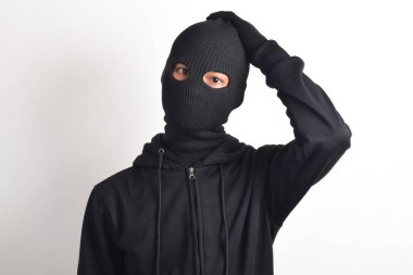 Siyah ceketli ve maskeli bir hırsız, beyaz arka planda soyutlanmış bir şekilde başını tutuyor. Hırsızlık ve suç kavramı