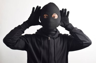 Beyaz arka planda siyah ceket ve maske giyen bir hırsız. Hırsızlık ve suç kavramı