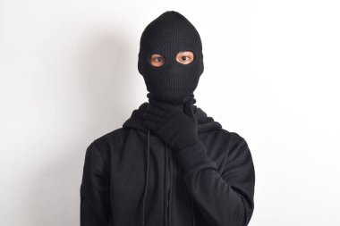 Beyaz arka planda siyah ceket ve maske giyen bir hırsız. Hırsızlık ve suç kavramı
