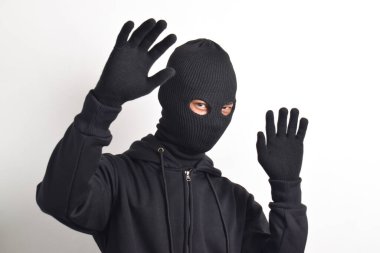 Siyah ceketli ve maskeli hırsız elleri havada yakalandı, beyaz arka planda izole edildi..