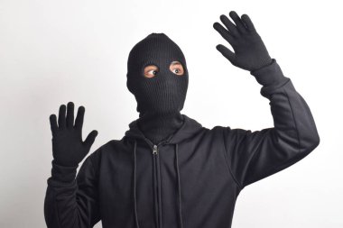 Siyah ceketli ve maskeli hırsız elleri havada yakalandı, beyaz arka planda izole edildi..