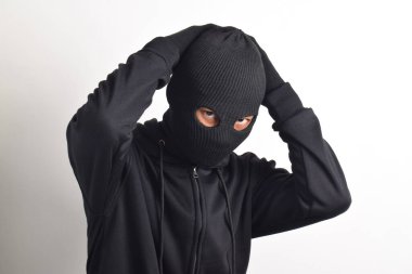 Siyah ceketli ve maskeli hırsız elleri havada yakalandı, beyaz arka planda izole edildi..
