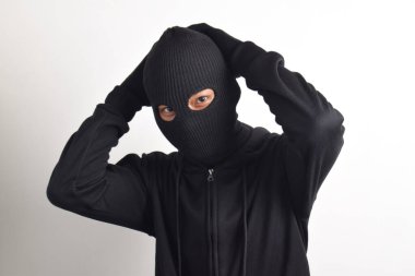Siyah ceketli ve maskeli hırsız elleri havada yakalandı, beyaz arka planda izole edildi..
