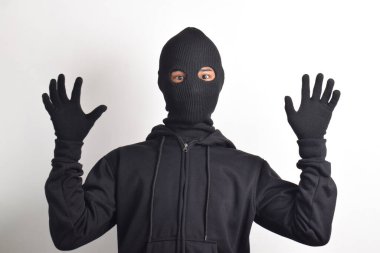 Siyah ceketli ve maskeli hırsız elleri havada yakalandı, beyaz arka planda izole edildi..