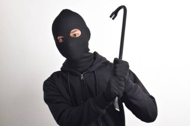 Siyah ceketli ve maskeli bir hırsız levye tutuyor, beyaz arka planda izole edilmiş..