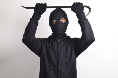 Siyah ceketli ve maskeli bir hırsız levye tutuyor, beyaz arka planda izole edilmiş..