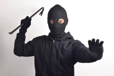 Siyah ceketli ve maskeli bir hırsız levye tutuyor, beyaz arka planda izole edilmiş..