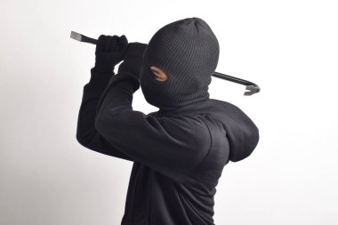 Siyah ceketli ve maskeli bir hırsız levye tutuyor, beyaz arka planda izole edilmiş..