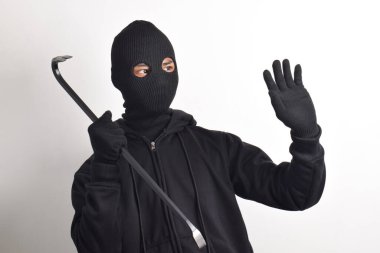 Siyah ceketli ve maskeli bir hırsız elinde korku dolu bir levyeyle beyaz arka planda izole edilmiş..
