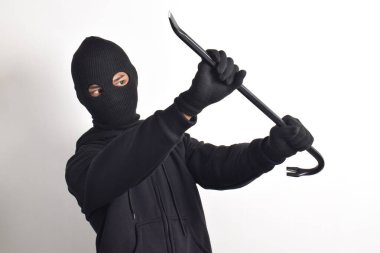 Siyah ceketli ve maskeli bir hırsız elinde korku dolu bir levyeyle beyaz arka planda izole edilmiş..