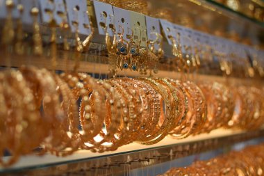 Bir kuyumcuda çeşitli lüks altın bilezikler sergileniyor.