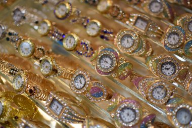 Madinah, Suudi Arabistan - 3 Mart 2025: Altın bantlı ve kristal aksanlı renkli kadın kol saatlerinin yakın çekimi.