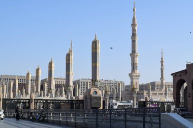Al-Madinah al-Munawwarah, Suudi Arabistan - 3 Mart 2025: Medine 'deki Peygamberin Mescid-i Haram, açık mavi gökyüzü altında açık mavi mimari sergilenen şemsiyeler ve uzun minareler.