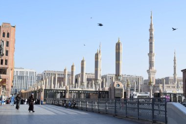 Al-Madinah al-Munawwarah, Suudi Arabistan - 3 Mart 2025: Medine 'deki Peygamberin Mescid-i Haram, açık mavi gökyüzü altında açık mavi mimari sergilenen şemsiyeler ve uzun minareler.