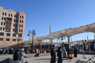 Al-Madinah al-Munawwarah, Suudi Arabistan - 3 Mart 2025: Açık mavi gökyüzü altında açık şemsiyeler ve minarelerle Medine 'deki Peygamber Camii.