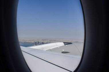 Gökyüzü açık mavi gökyüzü ve modern Katar şehir manzaralı Doha ufuk çizgisi ve uçak penceresinden kıyı şeridi.