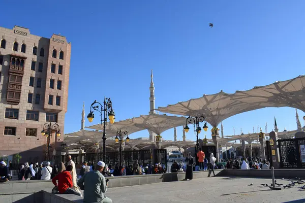Al-Madinah al-Munawwarah, Suudi Arabistan - 3 Mart 2025: Açık mavi gökyüzü altında açık şemsiyeler ve minarelerle Medine 'deki Peygamber Camii.