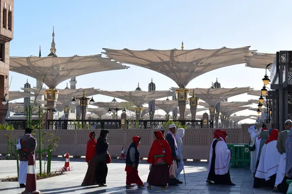 Al-Madinah al-Munawwarah, Suudi Arabistan - 3 Mart 2025: Açık mavi gökyüzü altında açık şemsiyeler ve minarelerle Medine 'deki Peygamber Camii.