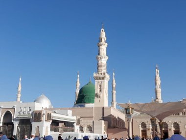 Al-Madinah al-Munawwarah, Suudi Arabistan - 1 Mart 2025: Peygamberin Medine 'deki yüksek minareleri açık mavi gökyüzü altında, İslami mimari sergilenen.