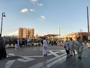 Al-Madinah al-Munawwarah, Suudi Arabistan - 4 Mart 2025: Açık mavi gökyüzü altında açık şemsiyeler ve minarelerle Medine 'deki Peygamberin Camii, İslami mimarinin sergilendiği.