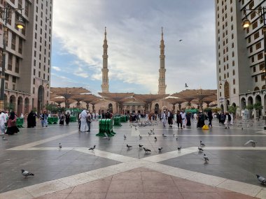 Al-Madinah al-Munawwarah, Suudi Arabistan - 5 Mart 2025: Açık mavi gökyüzü altında açık şemsiyeler ve minarelerle Medine 'deki Peygamber Camii, İslami mimariyi gözler önüne seriyor..
