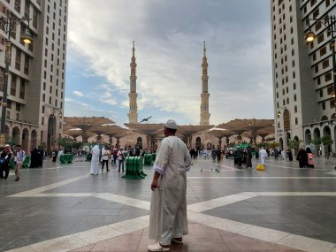 Al-Madinah al-Munawwarah, Suudi Arabistan - 5 Mart 2025: Açık mavi gökyüzü altında açık şemsiyeler ve minarelerle Medine 'deki Peygamber Camii, İslami mimariyi gözler önüne seriyor..