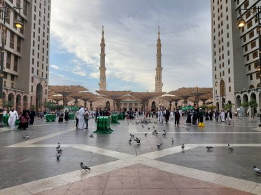 Al-Madinah al-Munawwarah, Suudi Arabistan - 5 Mart 2025: Açık mavi gökyüzü altında açık şemsiyeler ve minarelerle Medine 'deki Peygamber Camii, İslami mimariyi gözler önüne seriyor..