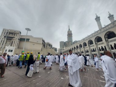 Makkah, Suudi Arabistan - 6 Mart 2025: Gökyüzü bulutlu olan Mescid-i Haram (Mescid-i Haram) ile hacı ve umre ziyaretçileri manzarası