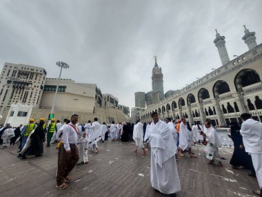 Makkah, Suudi Arabistan - 6 Mart 2025: Gökyüzü bulutlu olan Mescid-i Haram (Mescid-i Haram) ile hacı ve umre ziyaretçileri manzarası