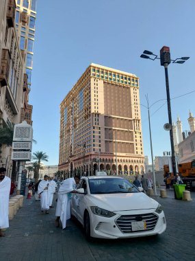 Makkah, Suudi Arabistan - 11 Mart 2025: Suudi Arabistan 'da Hac veya umrah yolcularını arayan beyaz sedan model bir arabayla taksi