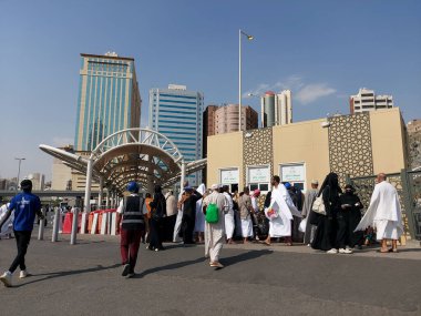 Makkah, Suudi Arabistan - 18 Mart 2025: Kalabalık güneşli bir gökyüzünün altında Makkah otobüs gişesinde toplanıyor. Mekke 'deki otobüs servisi için bilet satışı.
