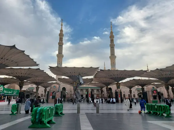 Al-Madinah al-Munawwarah, Suudi Arabistan - 5 Mart 2025: Açık mavi gökyüzü altında açık şemsiyeler ve minarelerle Medine 'deki Peygamber Camii, İslami mimariyi gözler önüne seriyor..