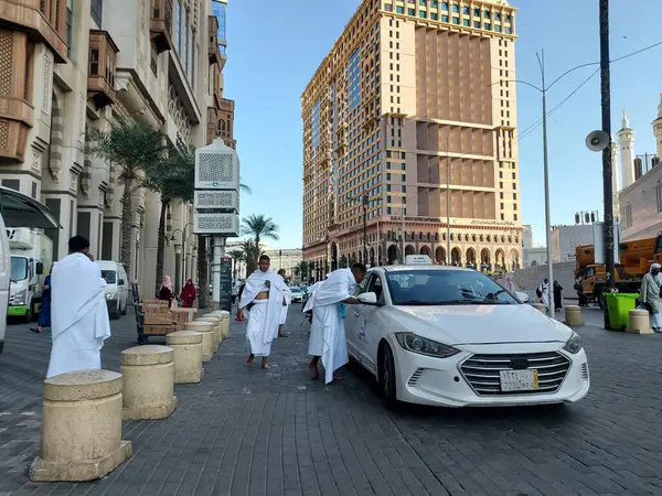 Makkah, Suudi Arabistan - 11 Mart 2025: Suudi Arabistan 'da Hac veya umrah yolcularını arayan beyaz sedan model bir arabayla taksi
