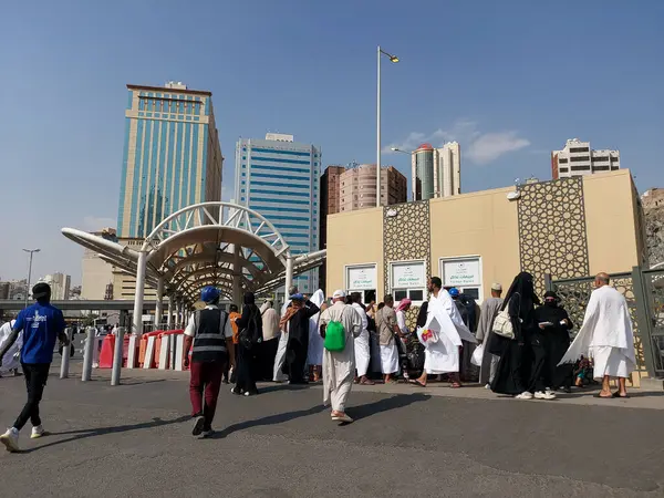 Makkah, Suudi Arabistan - 18 Mart 2025: Kalabalık güneşli bir gökyüzünün altında Makkah otobüs gişesinde toplanıyor. Mekke 'deki otobüs servisi için bilet satışı.