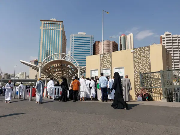 Makkah, Suudi Arabistan - 18 Mart 2025: Kalabalık güneşli bir gökyüzünün altında Makkah otobüs gişesinde toplanıyor. Mekke 'deki otobüs servisi için bilet satışı.