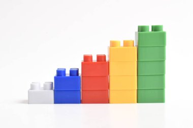Beyaz arka planda izole bir gökkuşağı renkli lego merdiveni. İnşa Blokları