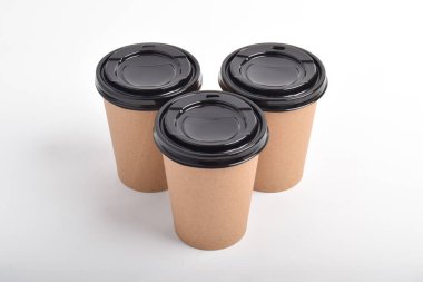 Beyaz arka planda üç tane kahverengi kahve fincanı var. Paket kahve kupası için boş Kraft