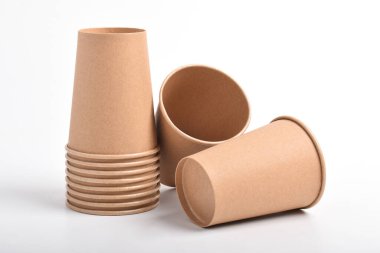 Beyaz arka planda izole edilmiş bir kağıt bardak yığını. Kartondan kahve fincanı.