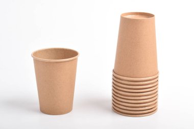 Beyaz arka planda izole edilmiş bir kağıt bardak yığını. Kartondan kahve fincanı.