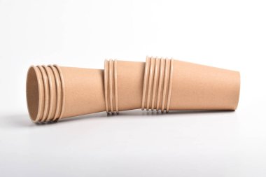 Beyaz arkaplanda izole edilmiş kahverengi kullan-at bardakların yığını.