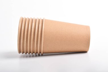 Beyaz arkaplanda izole edilmiş kahverengi kullan-at bardakların yığını.