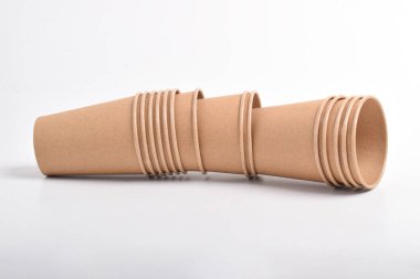 Beyaz arkaplanda izole edilmiş kahverengi kullan-at bardakların yığını.