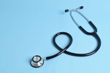 Açık mavi arka planda steteskop izole edildi. Kardiyoloji kavramı