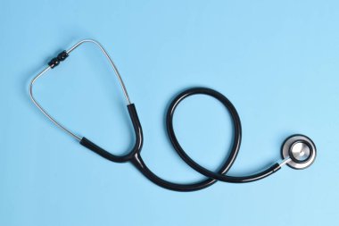 Açık mavi arka planda yeni steteskop, üst manzara. Tıbbi araç