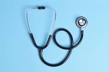 Açık mavi arka planda yeni steteskop, üst manzara. Tıbbi araç