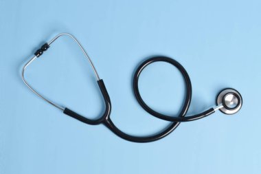 Açık mavi arka planda yeni steteskop, üst manzara. Tıbbi araç