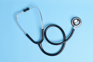 Açık mavi arka planda yeni steteskop, üst manzara. Tıbbi araç