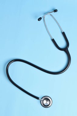 Açık mavi arka planda yeni steteskop, üst manzara. Tıbbi araç