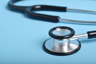 Açık mavi arkaplanda steteskop, yakın plan